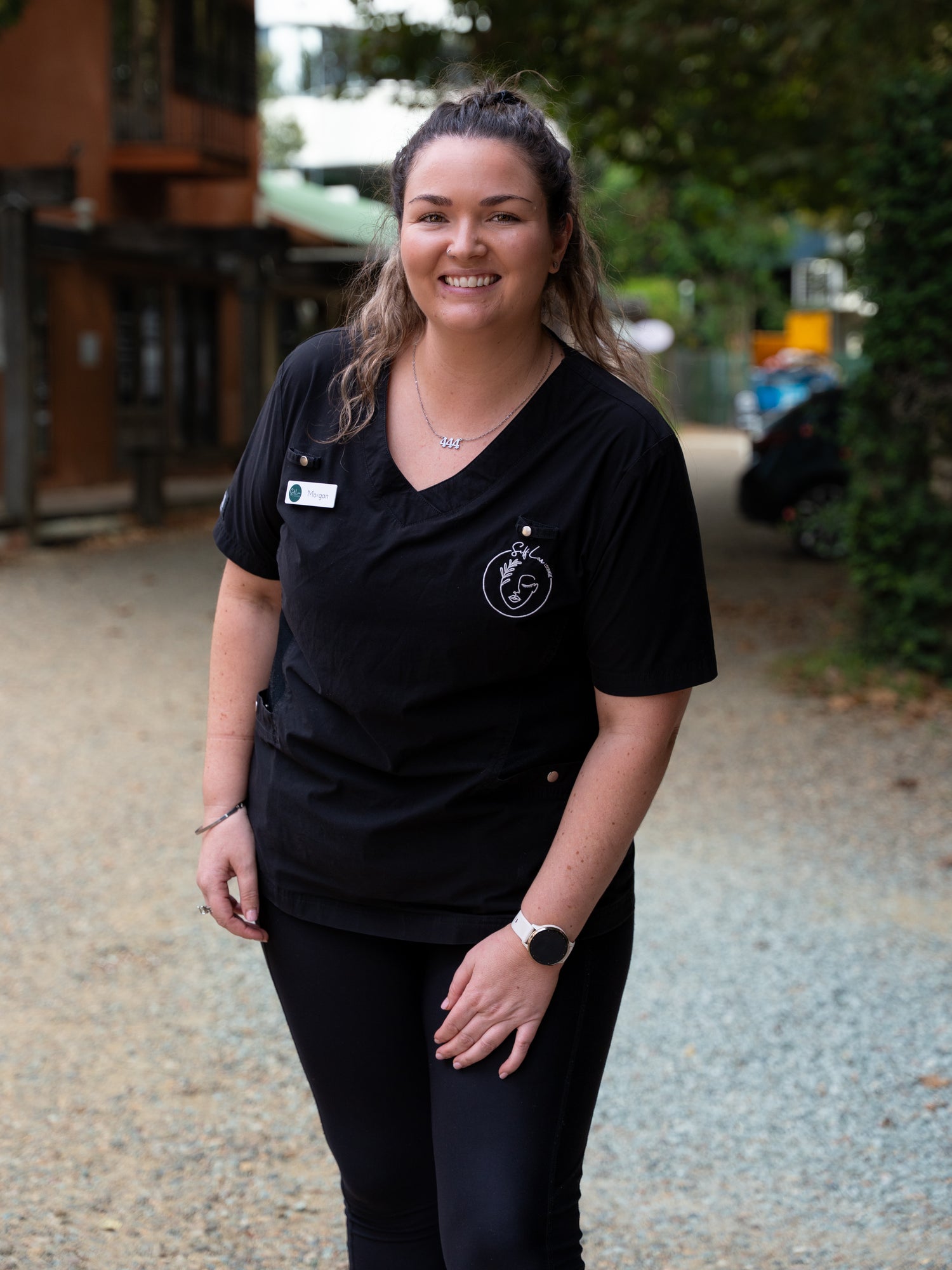 Morgan wearing a black shirt with a SLL logo, standing outdoors.
